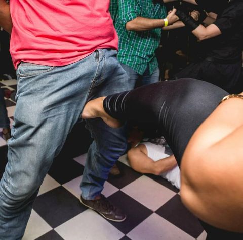Rainha Alma chutando o saco de um submisso em uma festa
